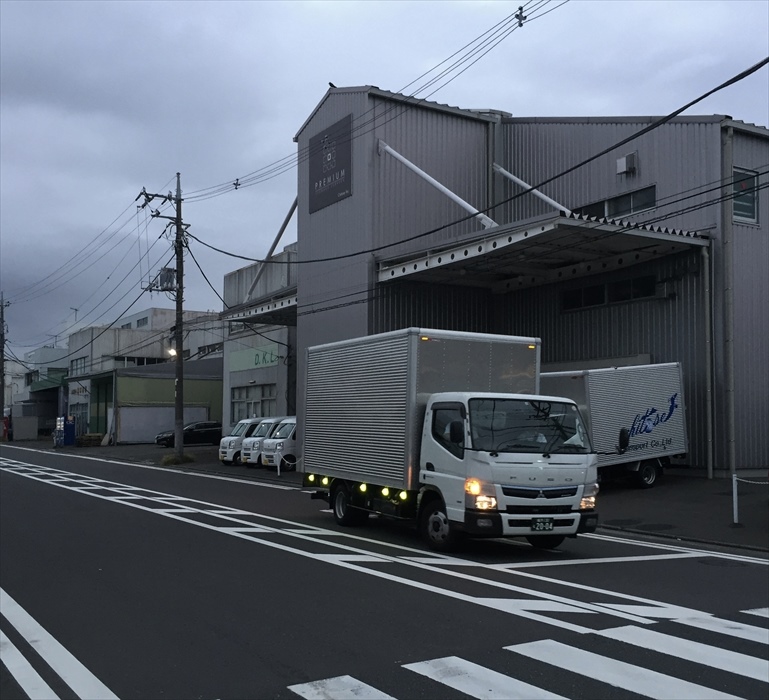 横浜本社倉庫を出発する自社トラック